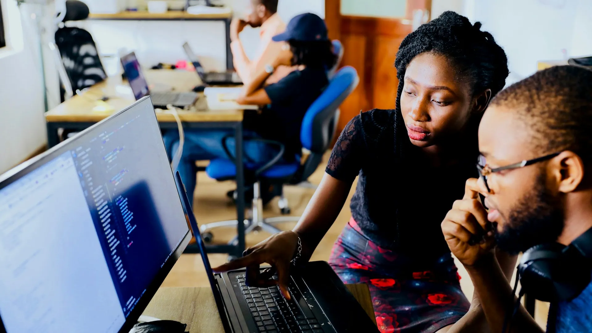 Two colleagues reviewing work on a laptop
